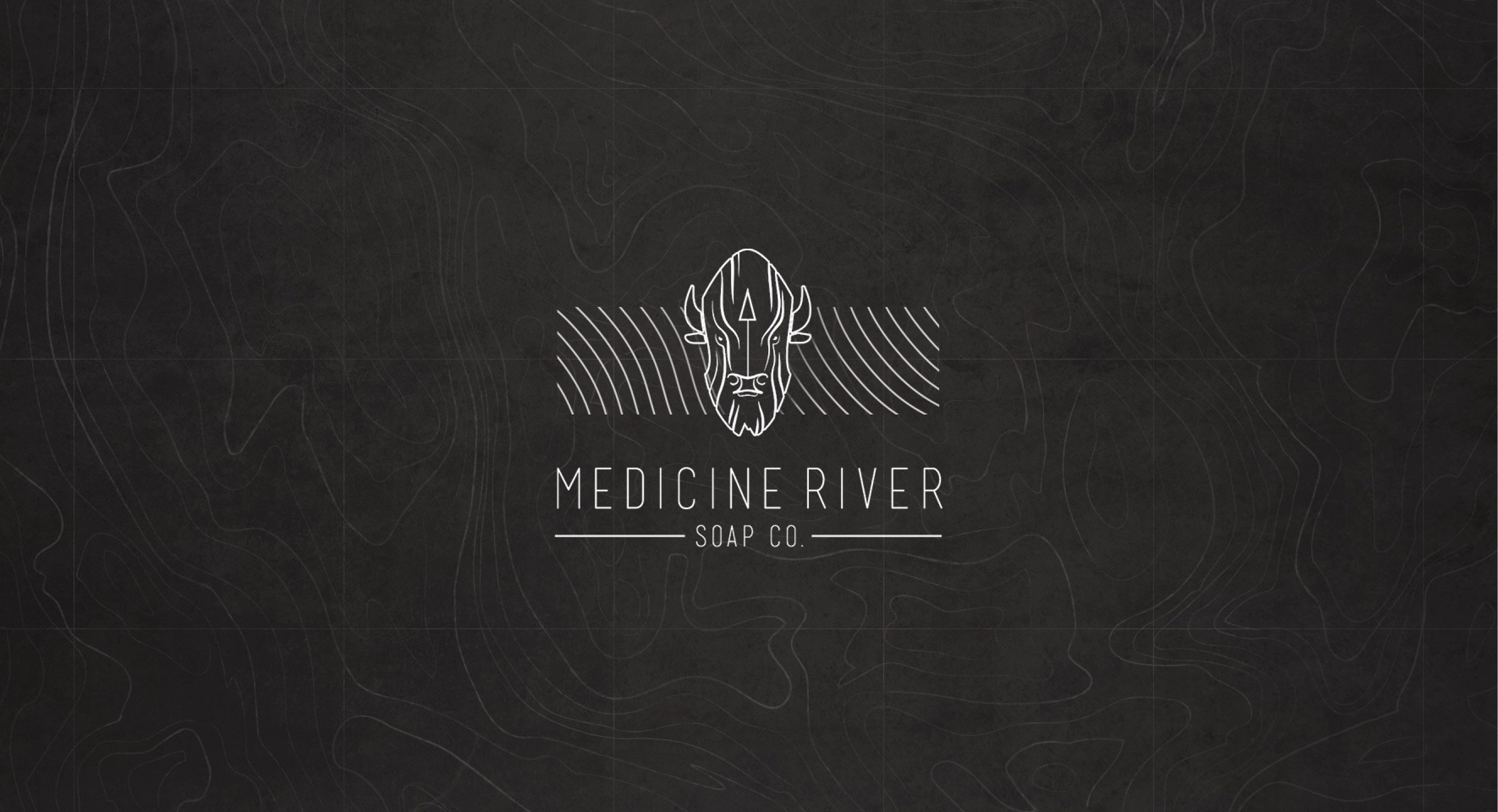 Medicine River Soap Co. bison symbol and wordmark over a topographic pattern